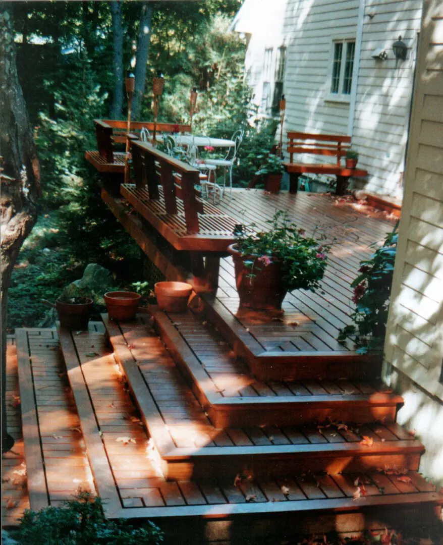 A wooden deck with steps and plants on it.